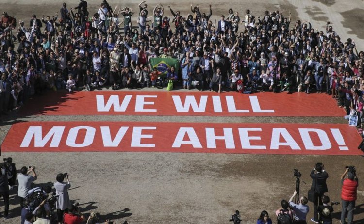 Participants at COP22, a follow-up on the Paris climate agreement, stage a public show of support for climate negotiations in Marrakech, Morocco, on Nov. 18. (AP Photo/David Keyton)