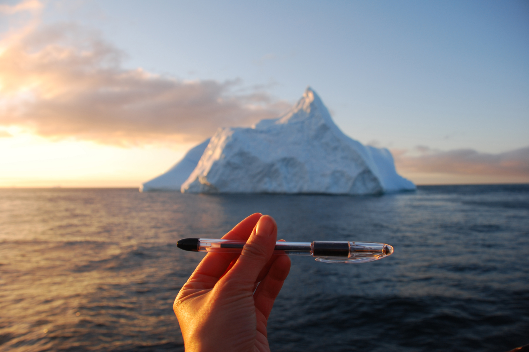 iceberg with a hand and pencil in the foreground
