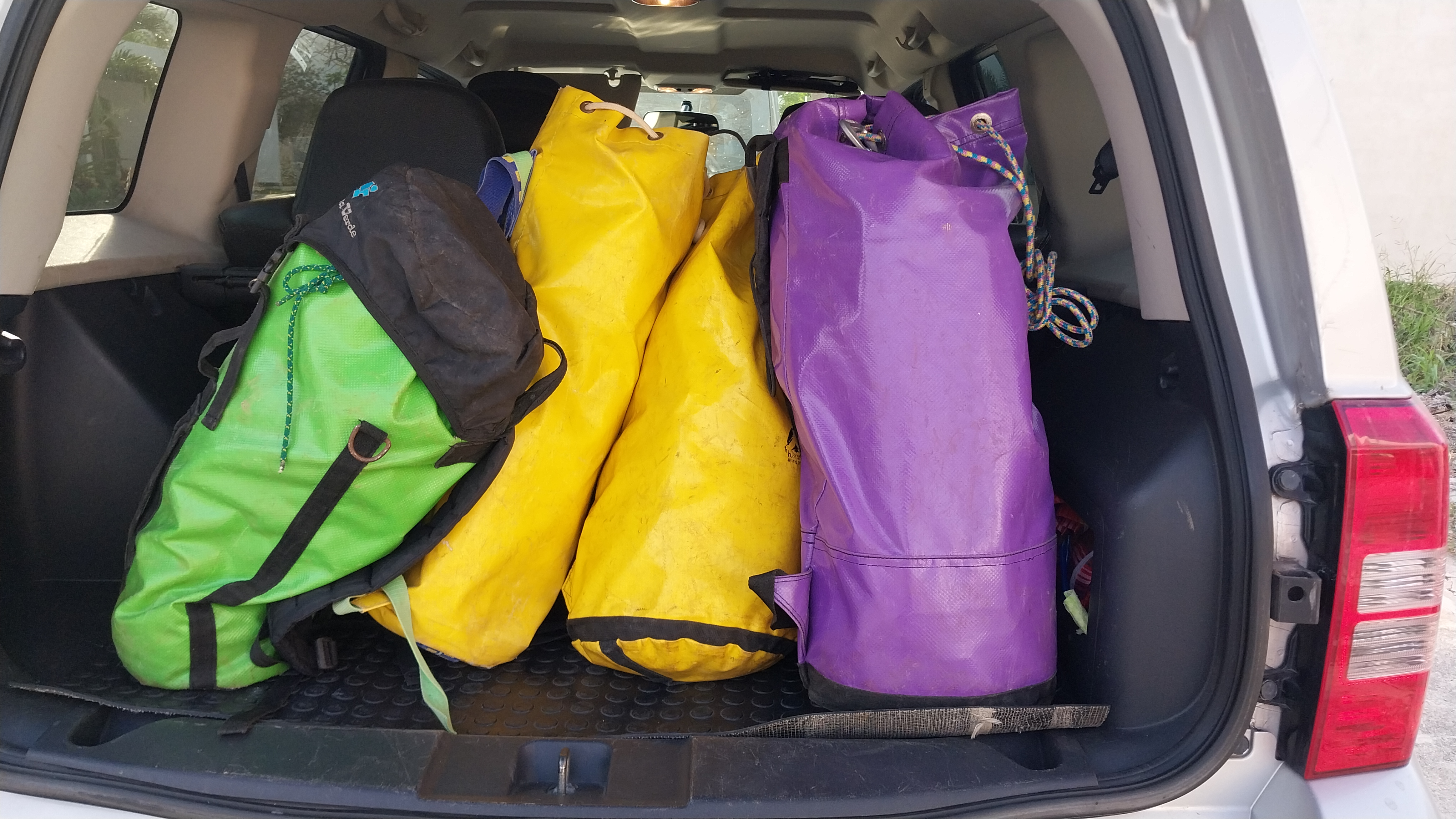 Colorful duffel bags in trunk of car