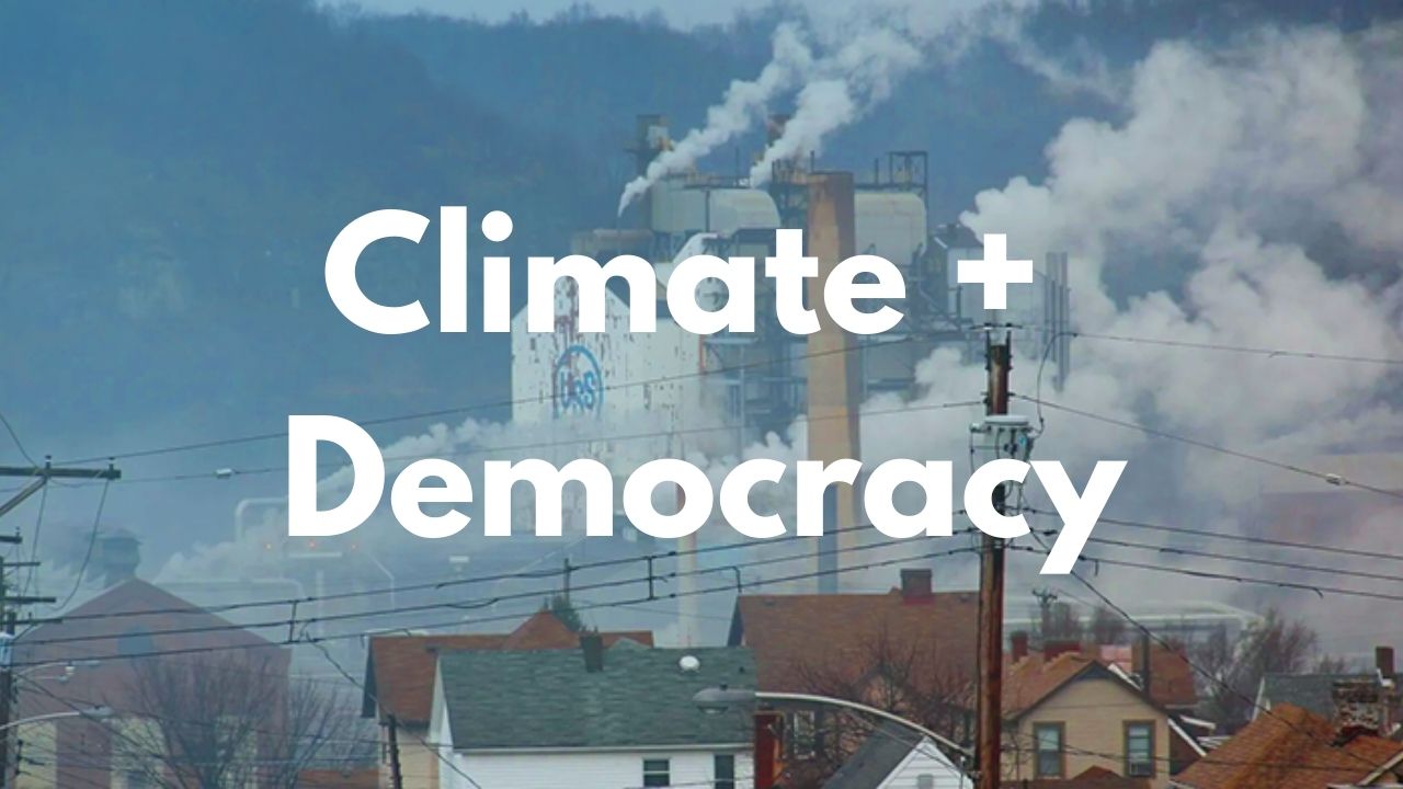 "Climate and democracy" over town with smoke emitting from industrial buildings.