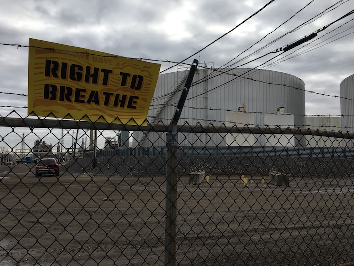 right to breathe sign on fenceline of refinery