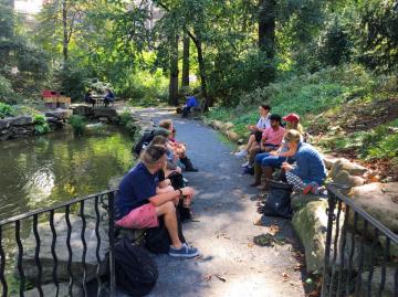 students and faculty member sitting by the biopond on the  University of Pennsylvania campus